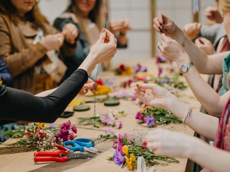 A group of women around a table covered in flowers for a hen party.